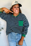 Woman wearing a striped sweater and cap with a neutral background