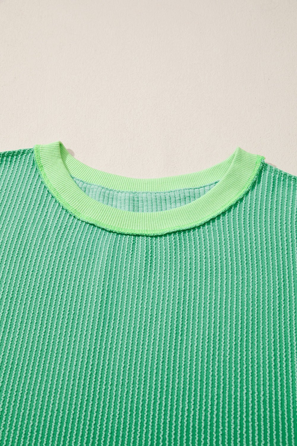 Green textured shirt with a green collar on a beige background
