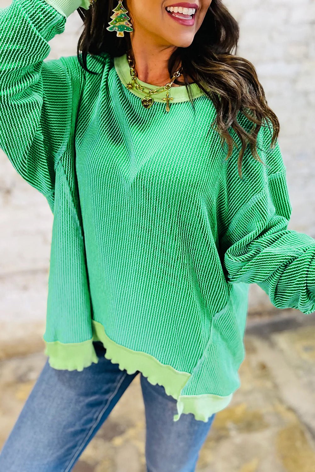 Person wearing a green sweater with a blurred background