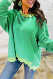 Person wearing a green sweater with a blurred background