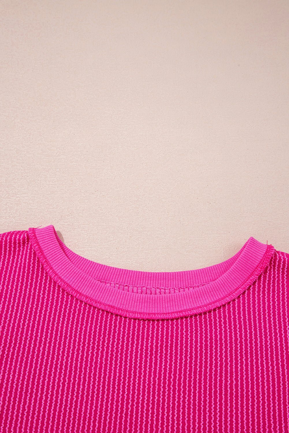 Close-up of a pink textured garment on a beige background