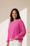 Woman wearing a pink sweater against a beige background