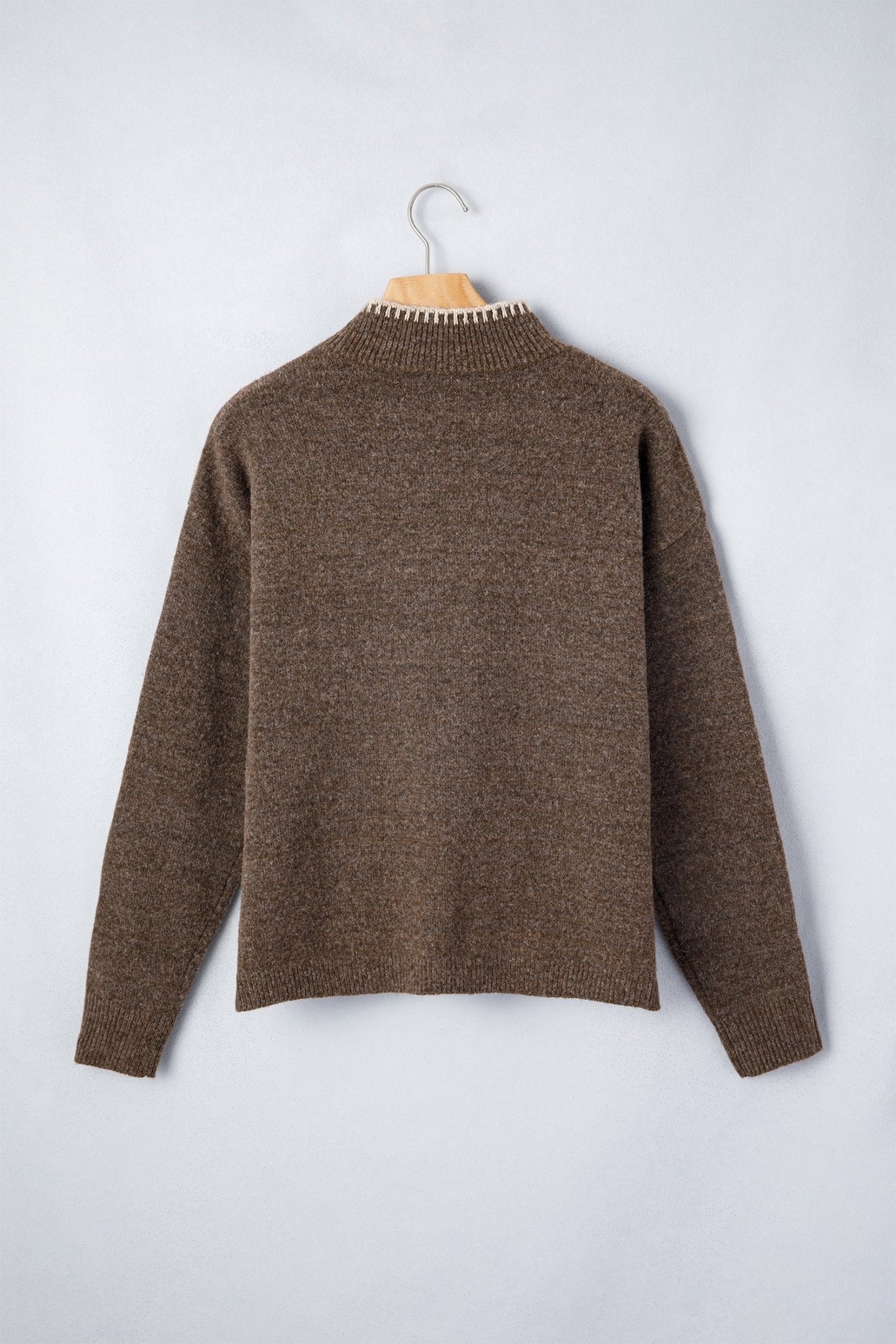 A brown knit sweater with a textured, heathered finish, hanging on a wooden hanger against a light gray background.