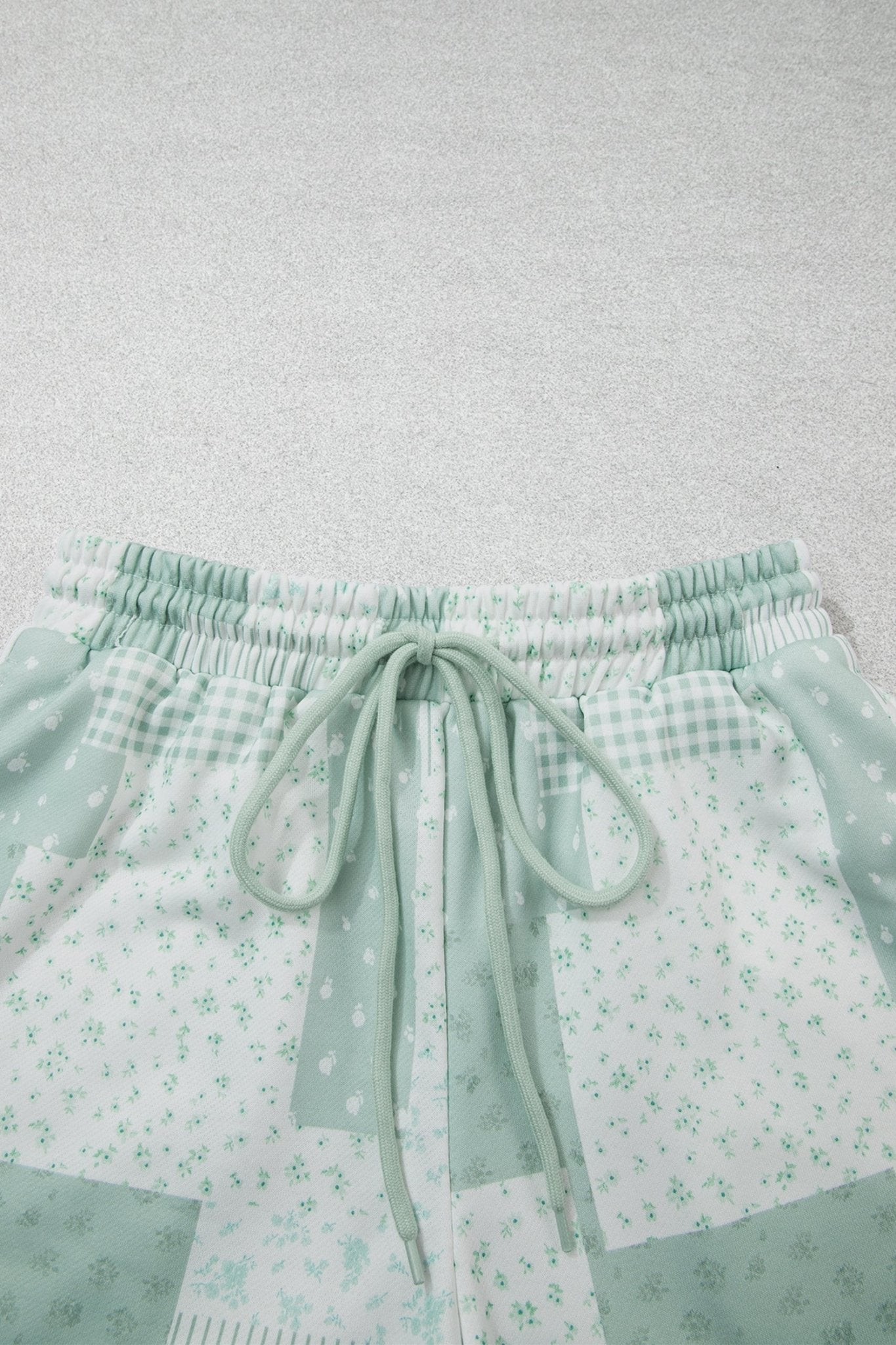 Mint green patchwork shorts with gingham, floral print, and drawstring waist.