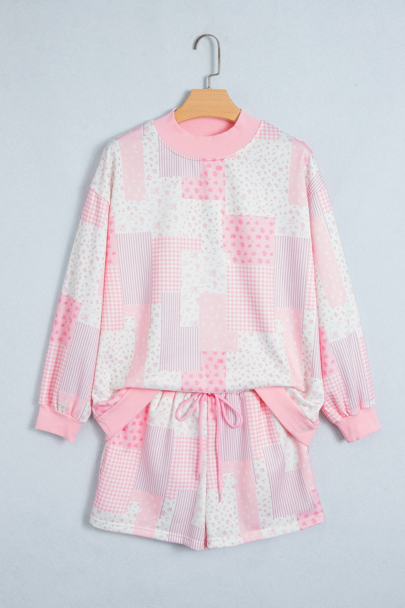 Girls’ pink and white patchwork pajama set with long-sleeve top and shorts.