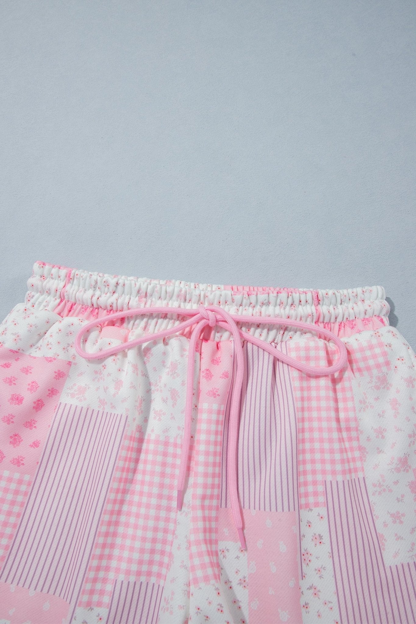 Co-ord pink floral patchwork loungewear featuring a crewneck sweatshirt and matching shorts.