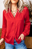 Woman in vibrant red lace-detail button-up blouse with blue jeans.