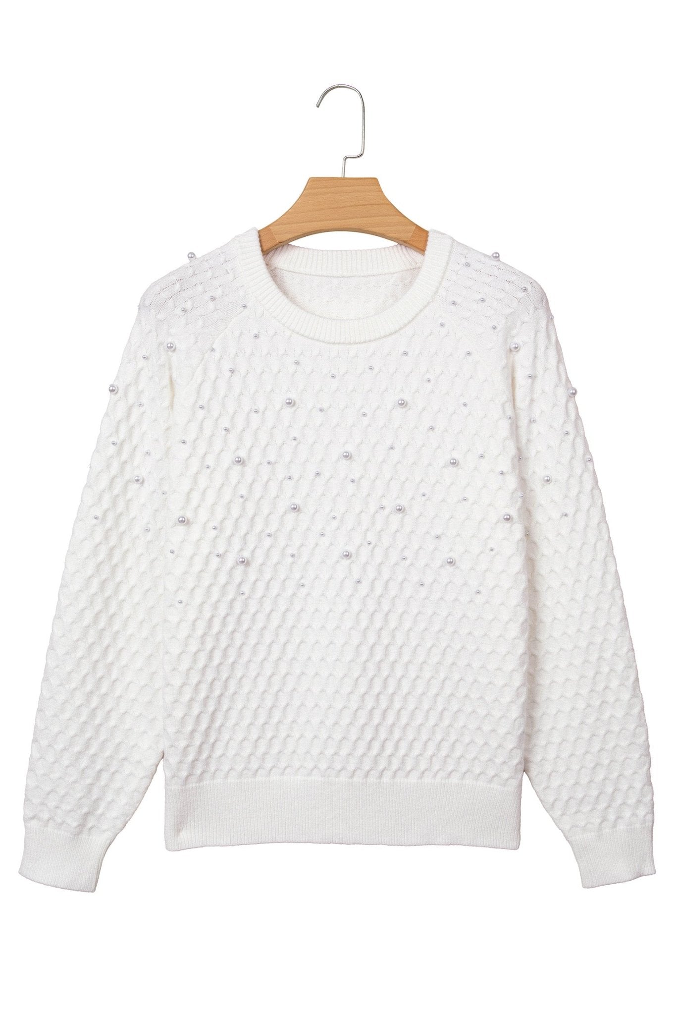 Off-white textured knit sweater with raised dot details on a wooden hanger against a white background.