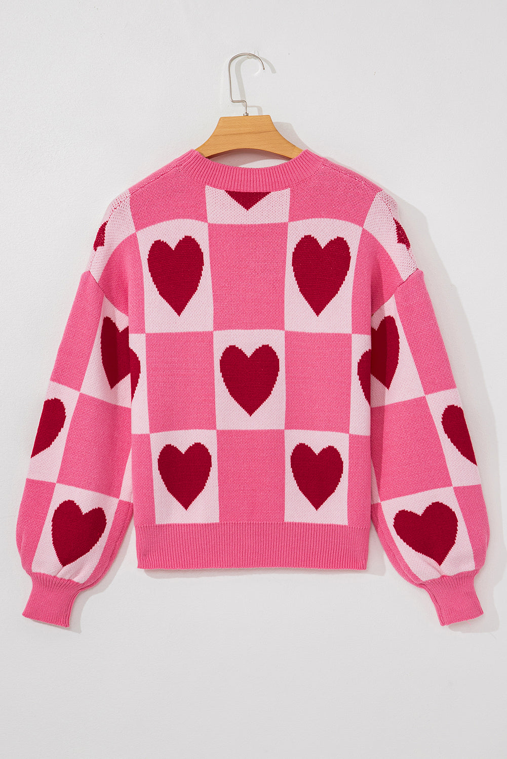 Pink heart checkered Valentine sweater on a hanger, back view