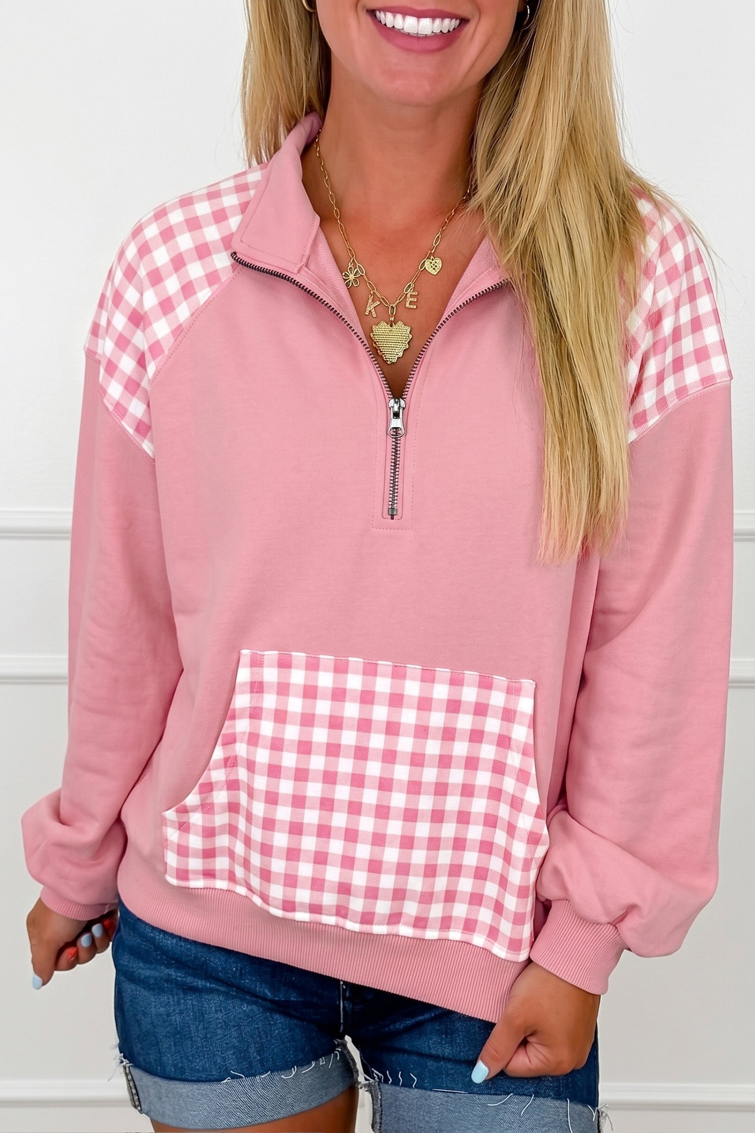 Pink plaid patchwork quarter zip sweatshirt with gingham kangaroo pocket, front view