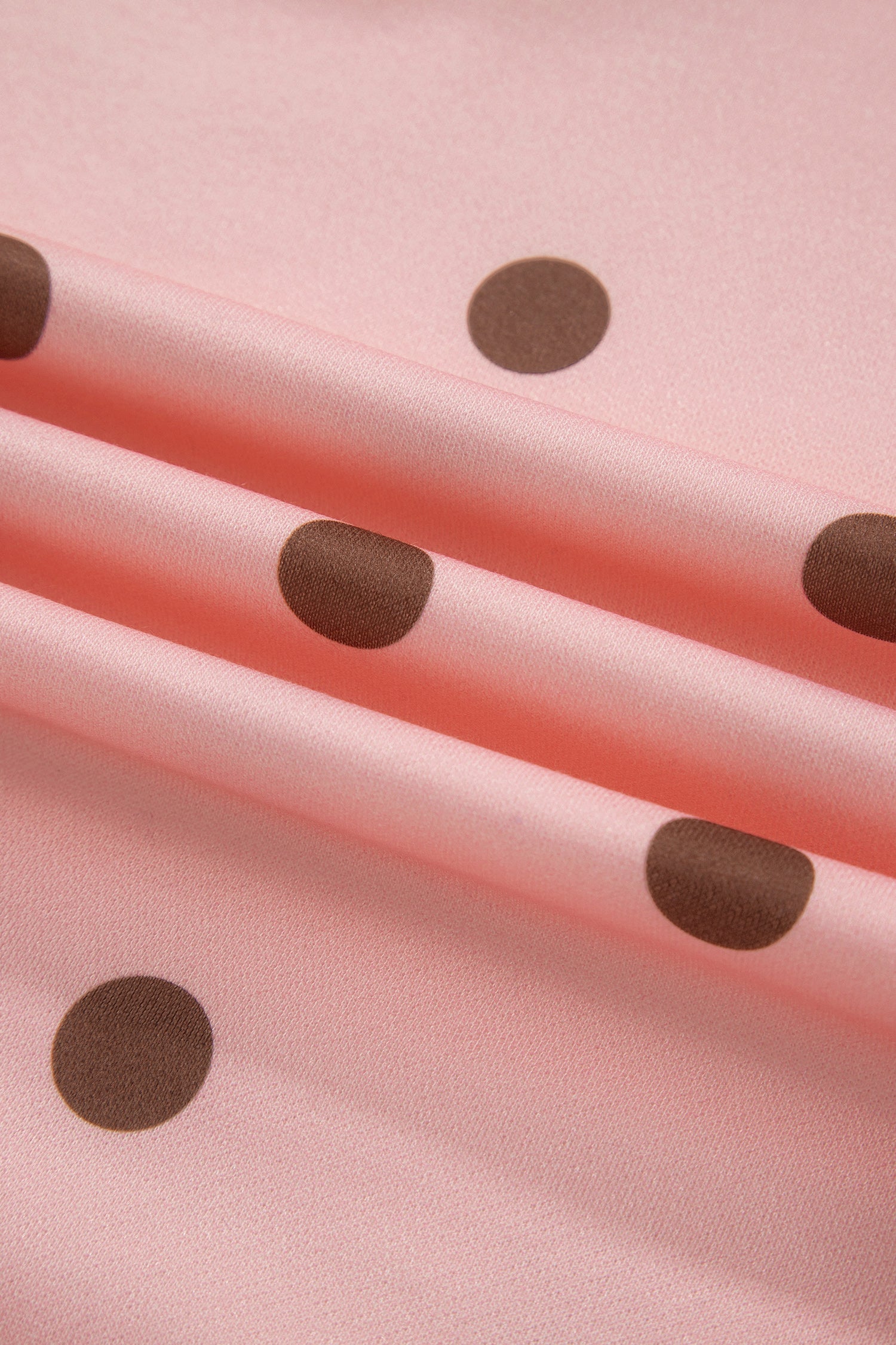 Polka dot print fabric texture on pink set, close-up