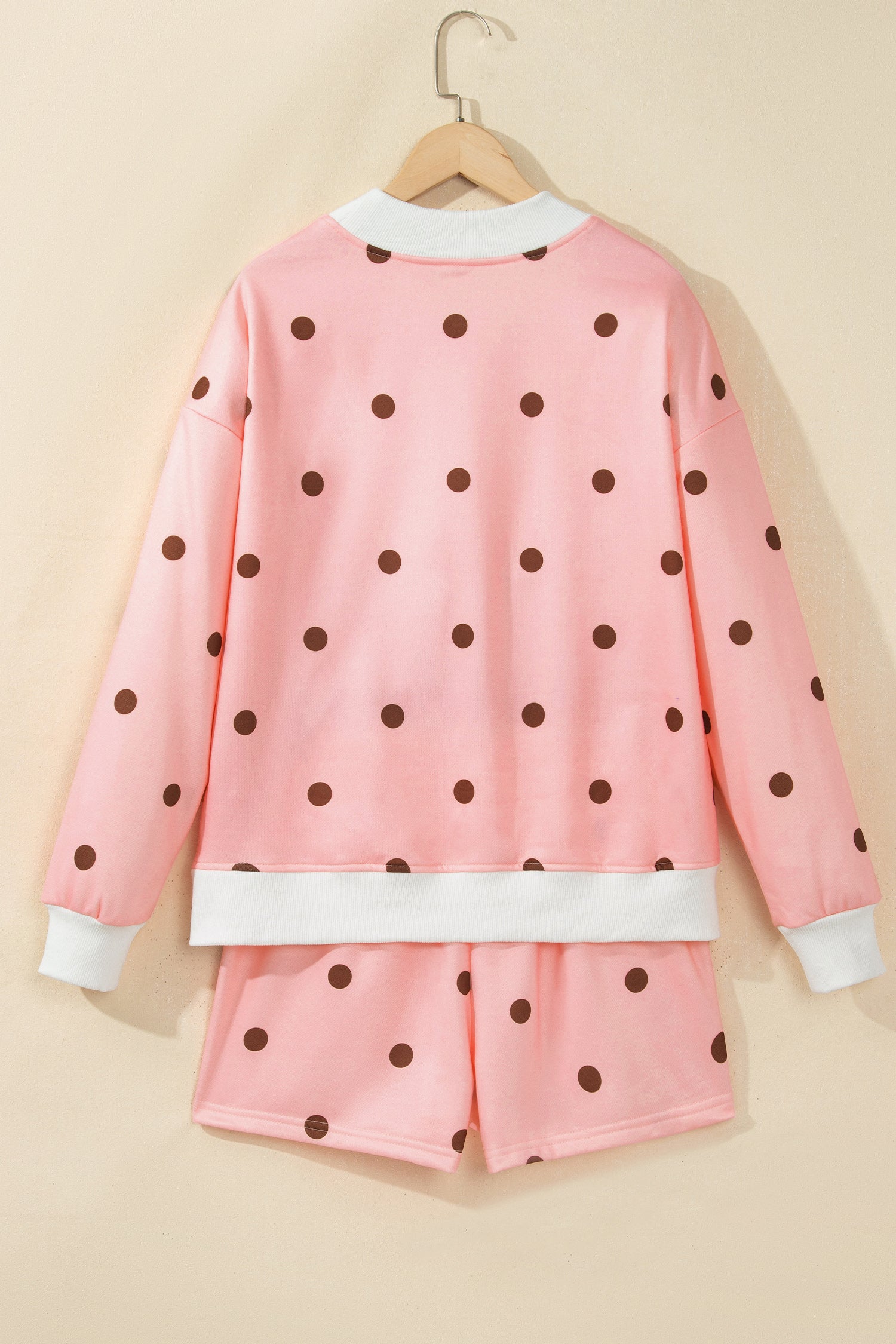 Pink polka dot top and shorts set on hanger, back view