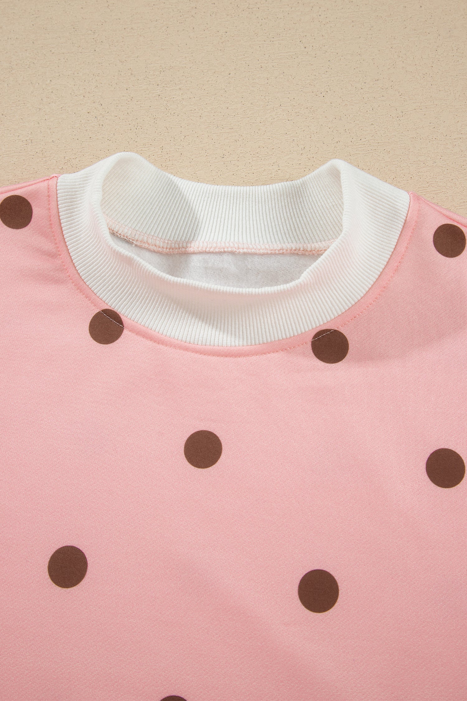 Contrast white ribbed crew neckline on pink polka dot top