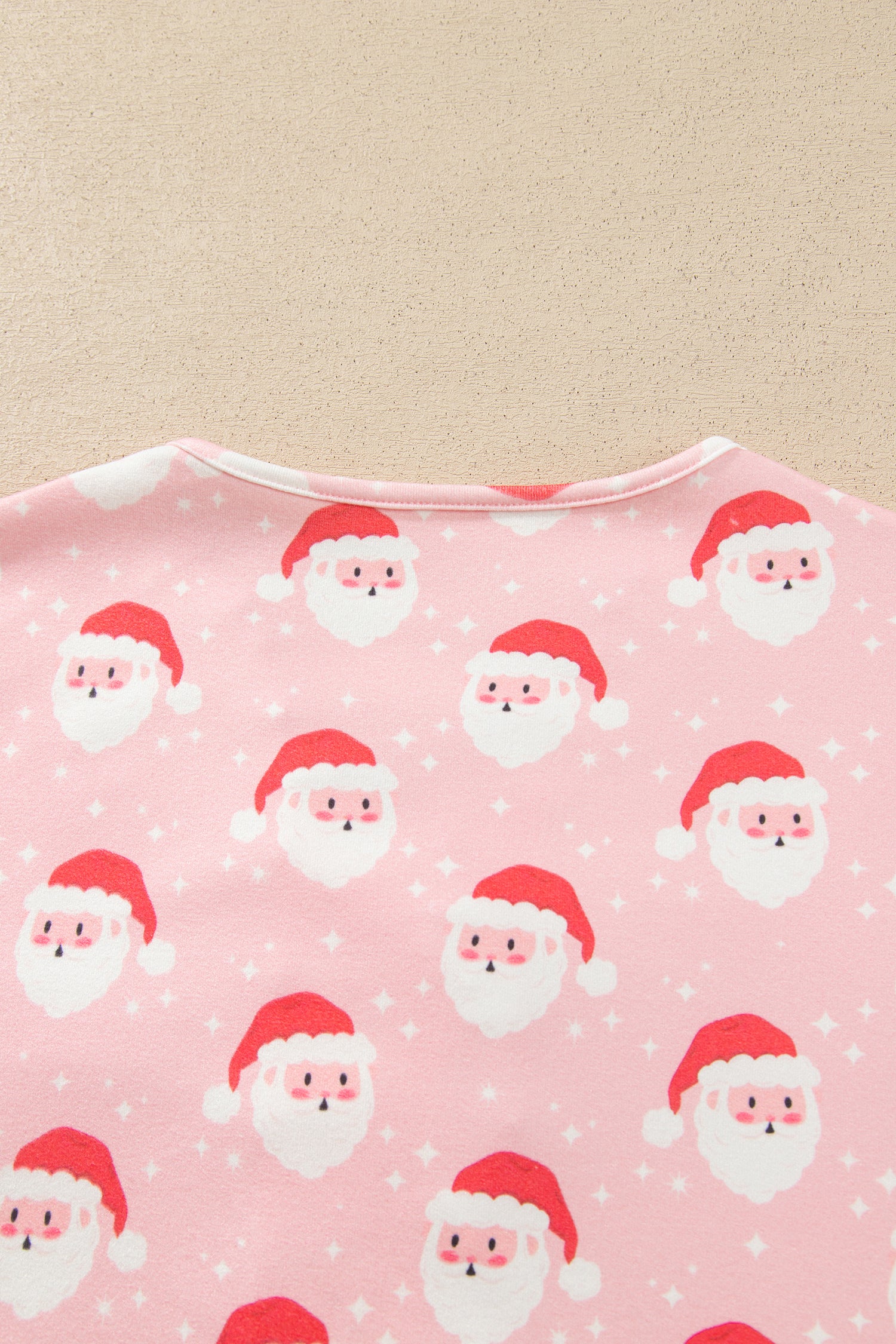 Back neckline of pink Santa print pajama top with white star accents