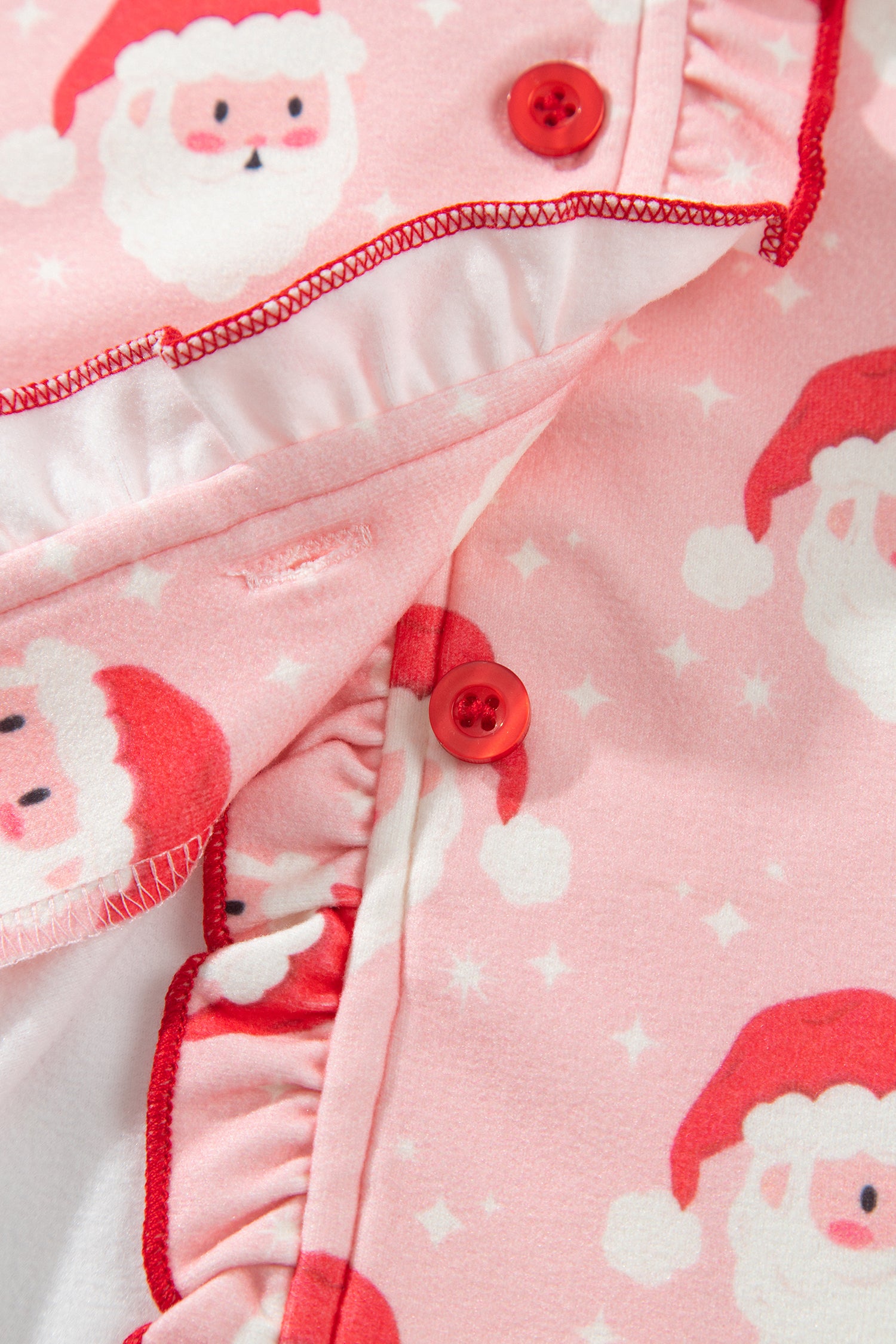 Inside view of button placket with red ruffle trim on Santa print pajama top