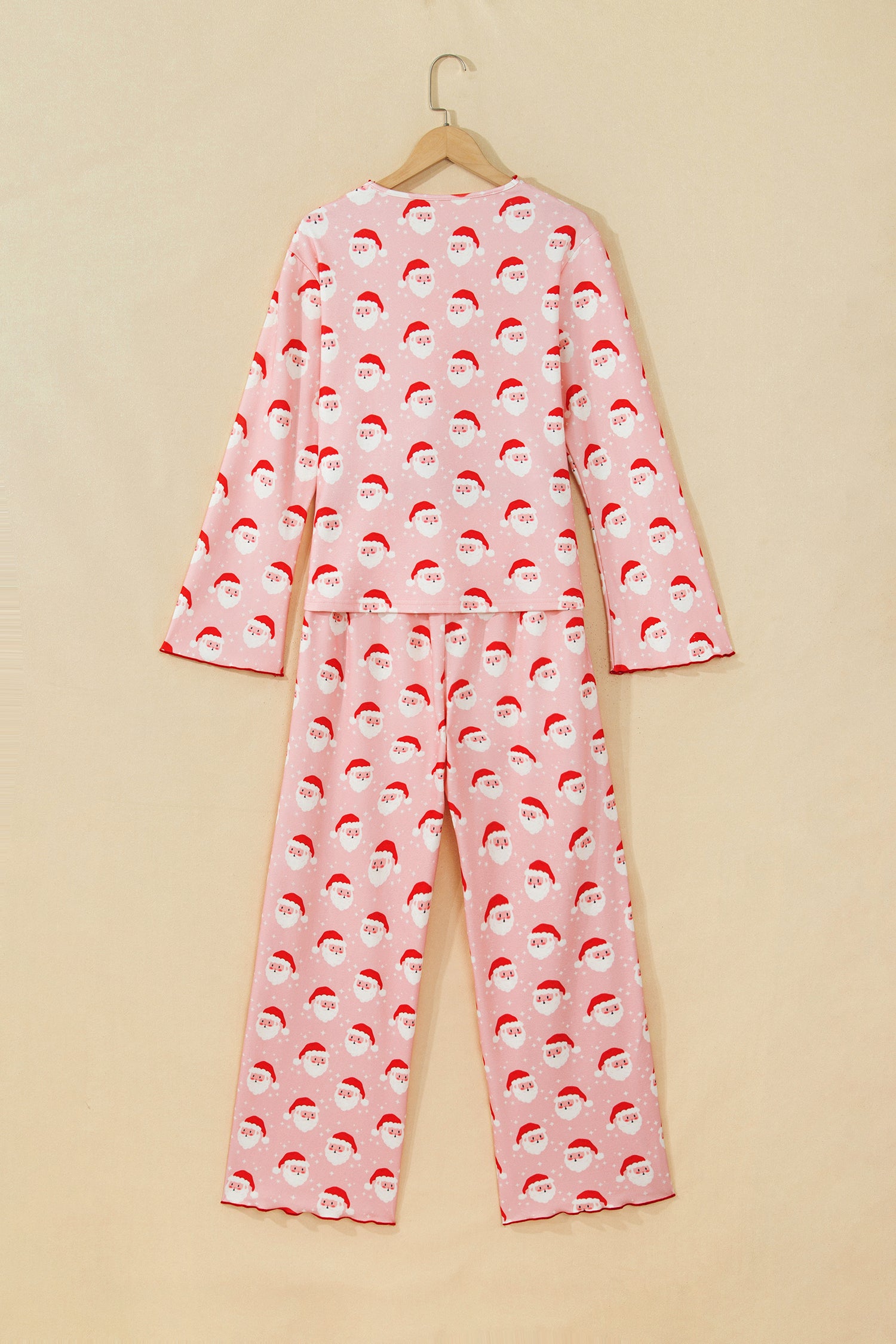 Pink Santa print Christmas lounge set with red lettuce edge trim on a hanger, back view