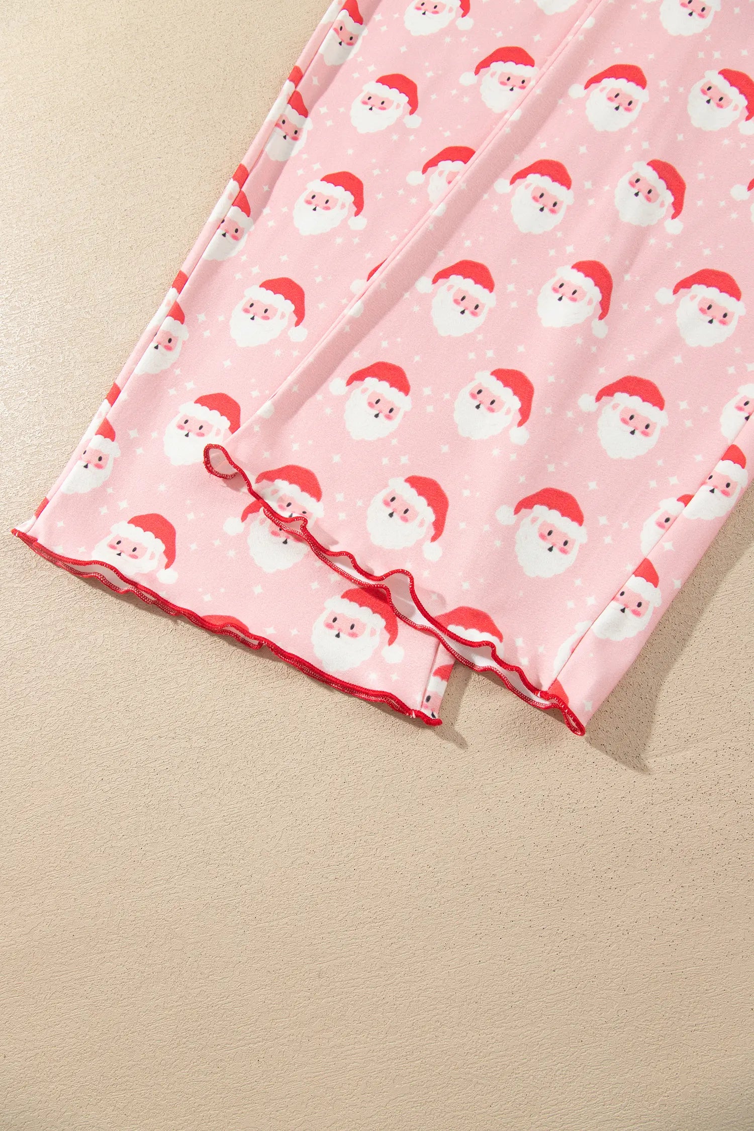Red lettuce edge hems on pink Santa print wide leg lounge pants