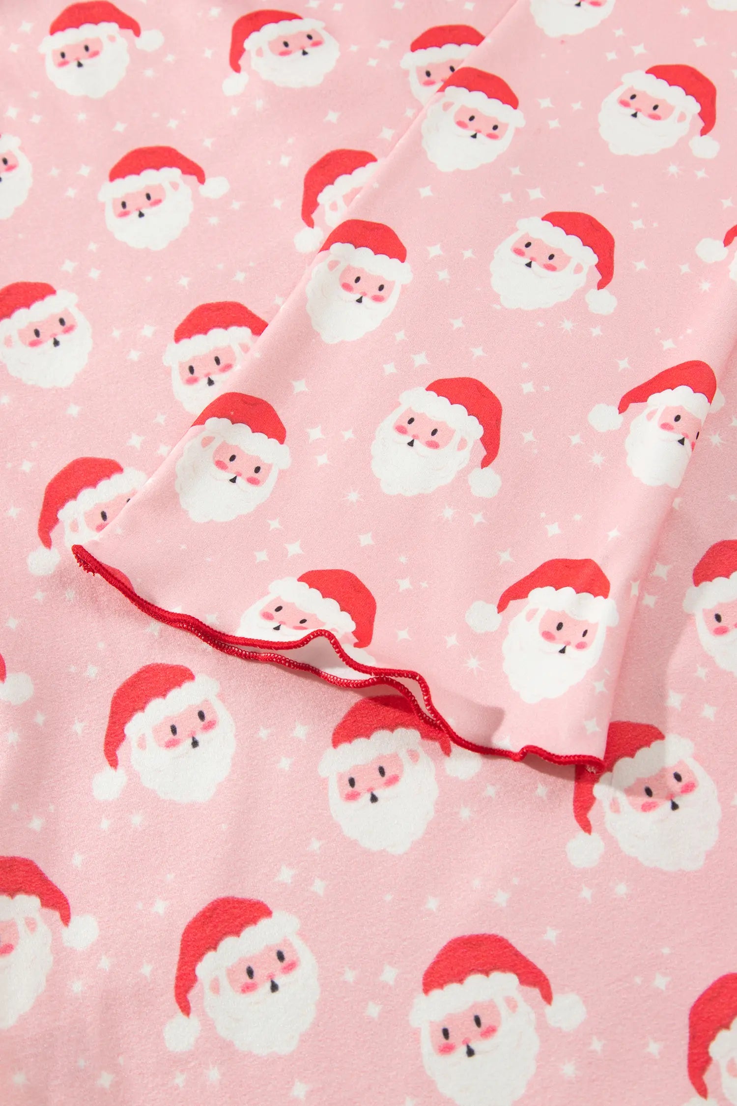 Close-up of pink Santa print sleeve with red lettuce edge hem