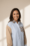 Woman wearing a striped shirt with leopard print accents against a neutral background