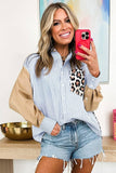 Woman taking a selfie with a red phone, wearing a striped shirt and denim shorts, in a room with a painting and decorative items.