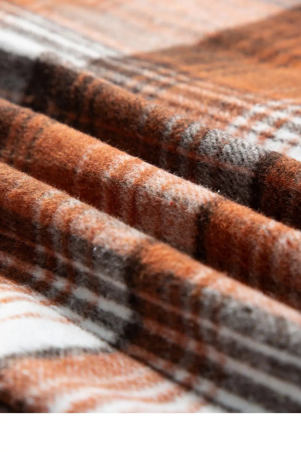 Close-up of a plaid fabric with brown, gray, and white colors.