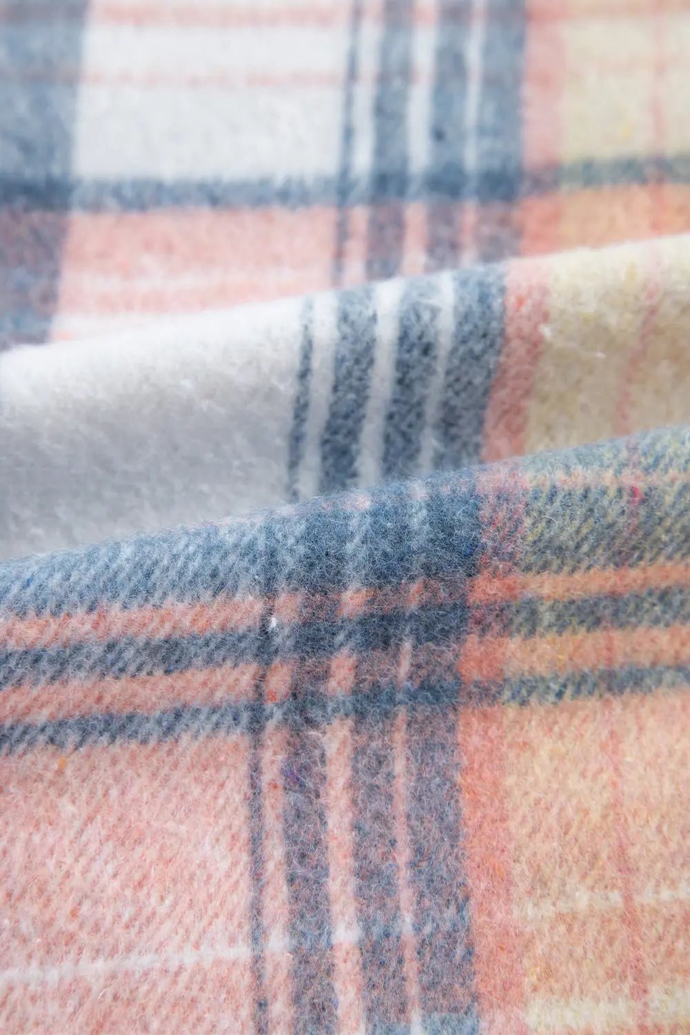 Close-up of plaid fabric with pink, blue, and white colors.