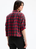 Person wearing a red and black plaid shirt on a white background