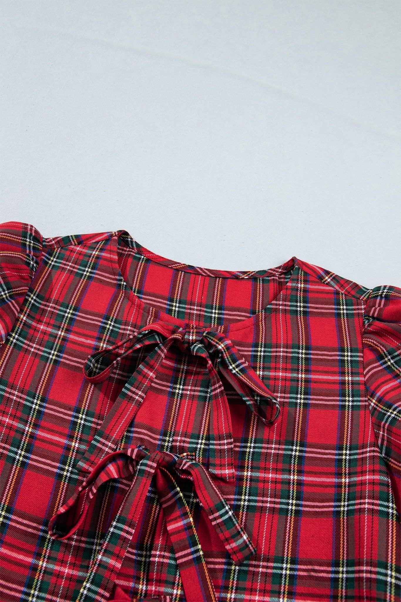 Red tartan blouse with puff sleeves and satin bow.