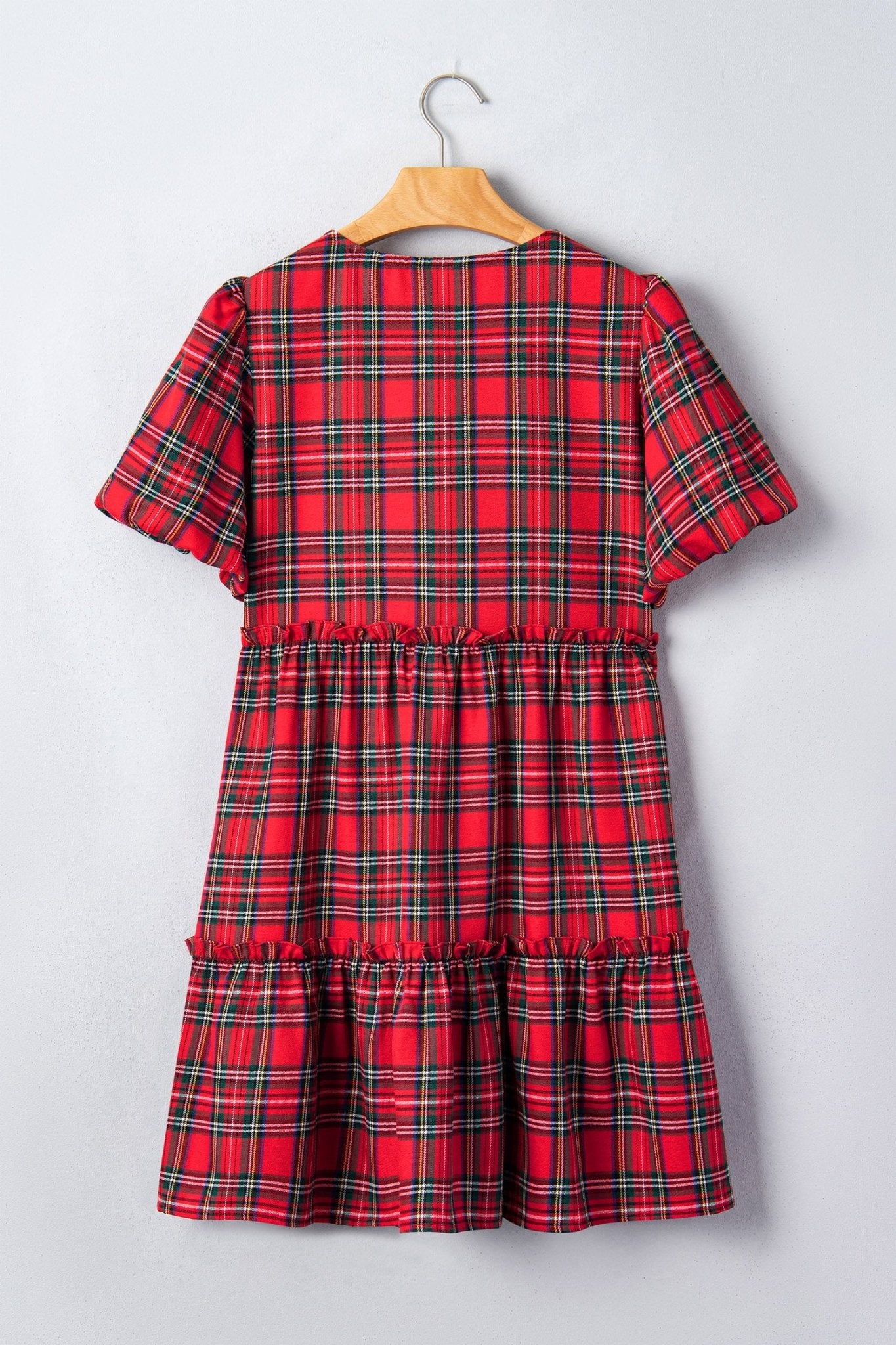 Red tartan short-sleeve dress on wooden hanger.