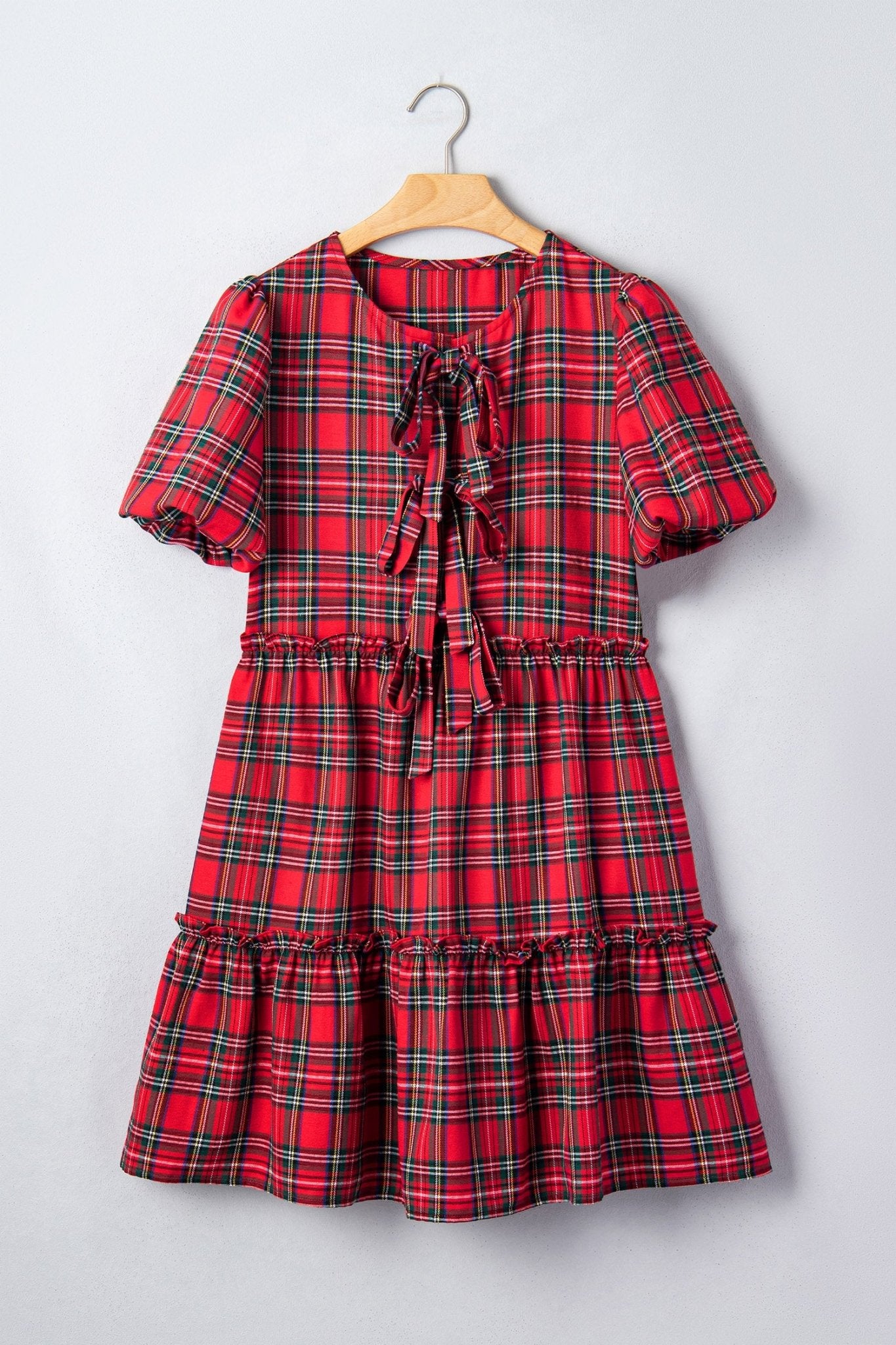 Red green plaid short-sleeve dress on wooden hanger.