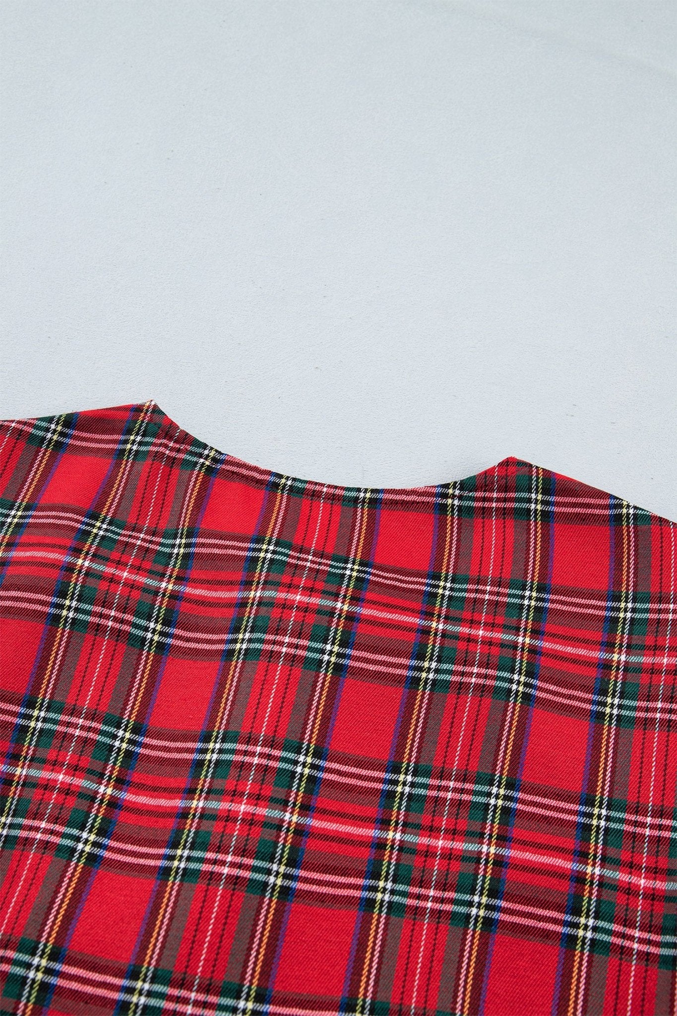 Red tartan plaid fabric with black, green, and white stripes.