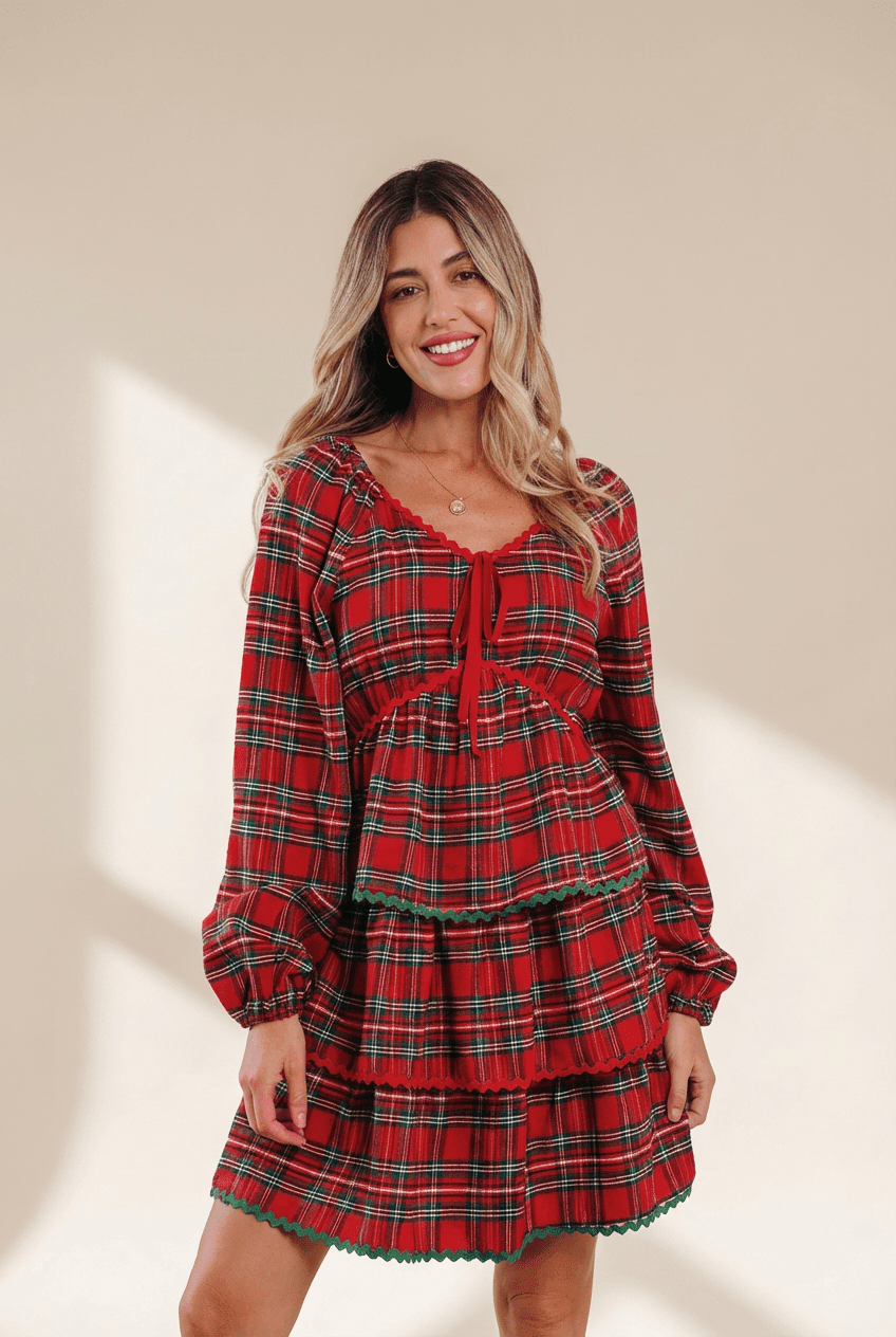 Woman wearing a red plaid dress against a beige background