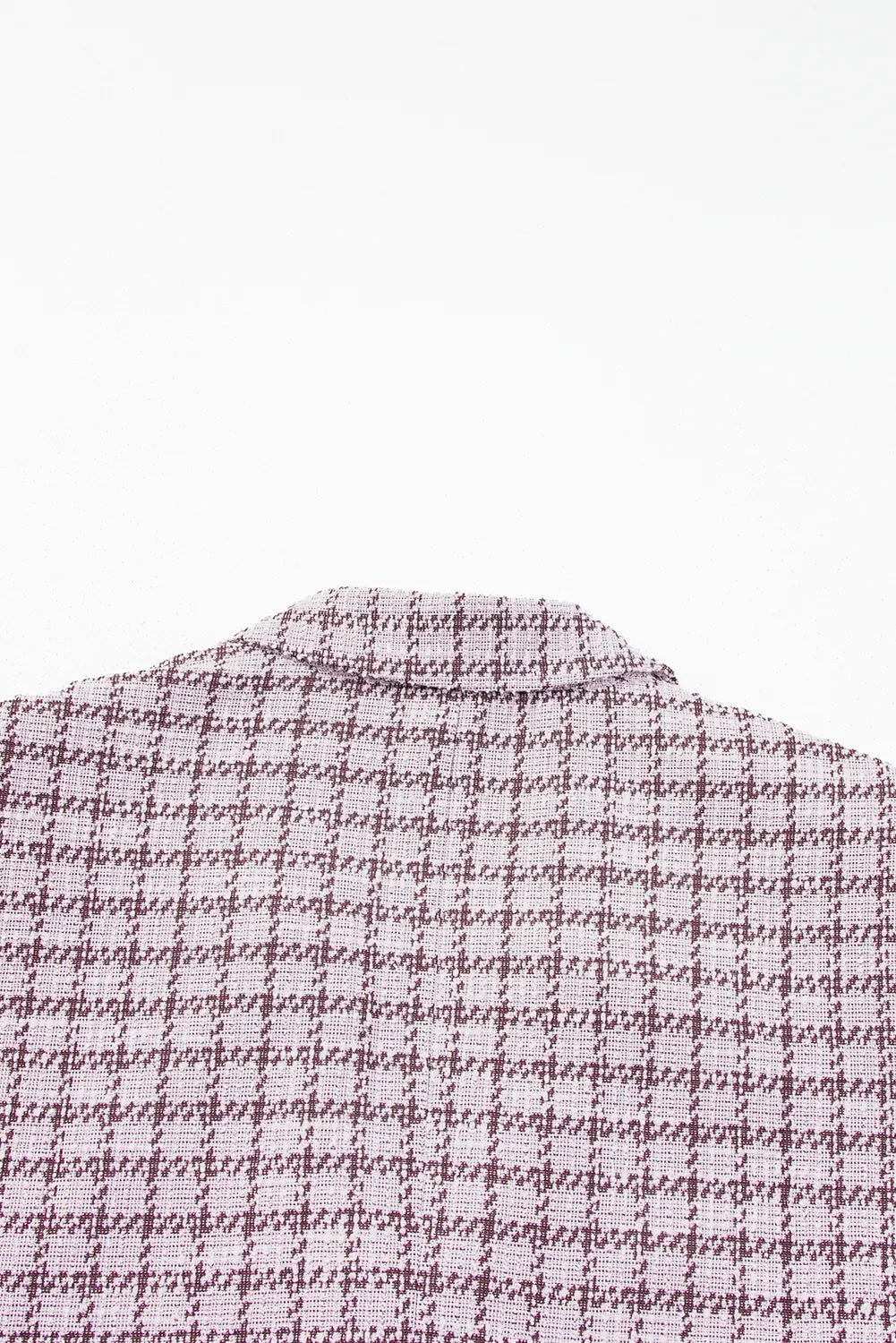 A close-up of a woven fabric with a small-scale houndstooth pattern in purple and white, showing the texture and color details.