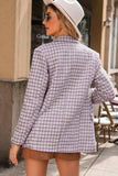 Woman wearing a checkered blazer and white hat outdoors.
