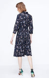 Woman wearing a navy floral dress on a white background