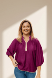 Woman wearing a purple blouse with a neutral background