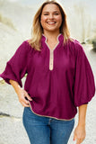 Woman wearing a purple blouse with a blurred natural background