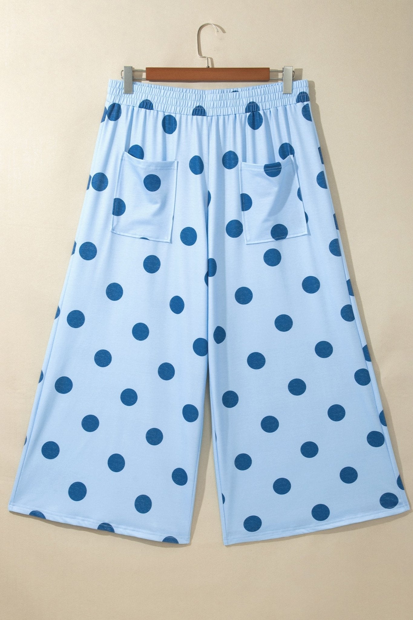 Light blue cropped wide-leg pants with dark blue polka dots, patch pockets, and elastic waistband.