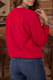 Back view of woman in bright red sweatshirt and blue jeans in rustic setting.