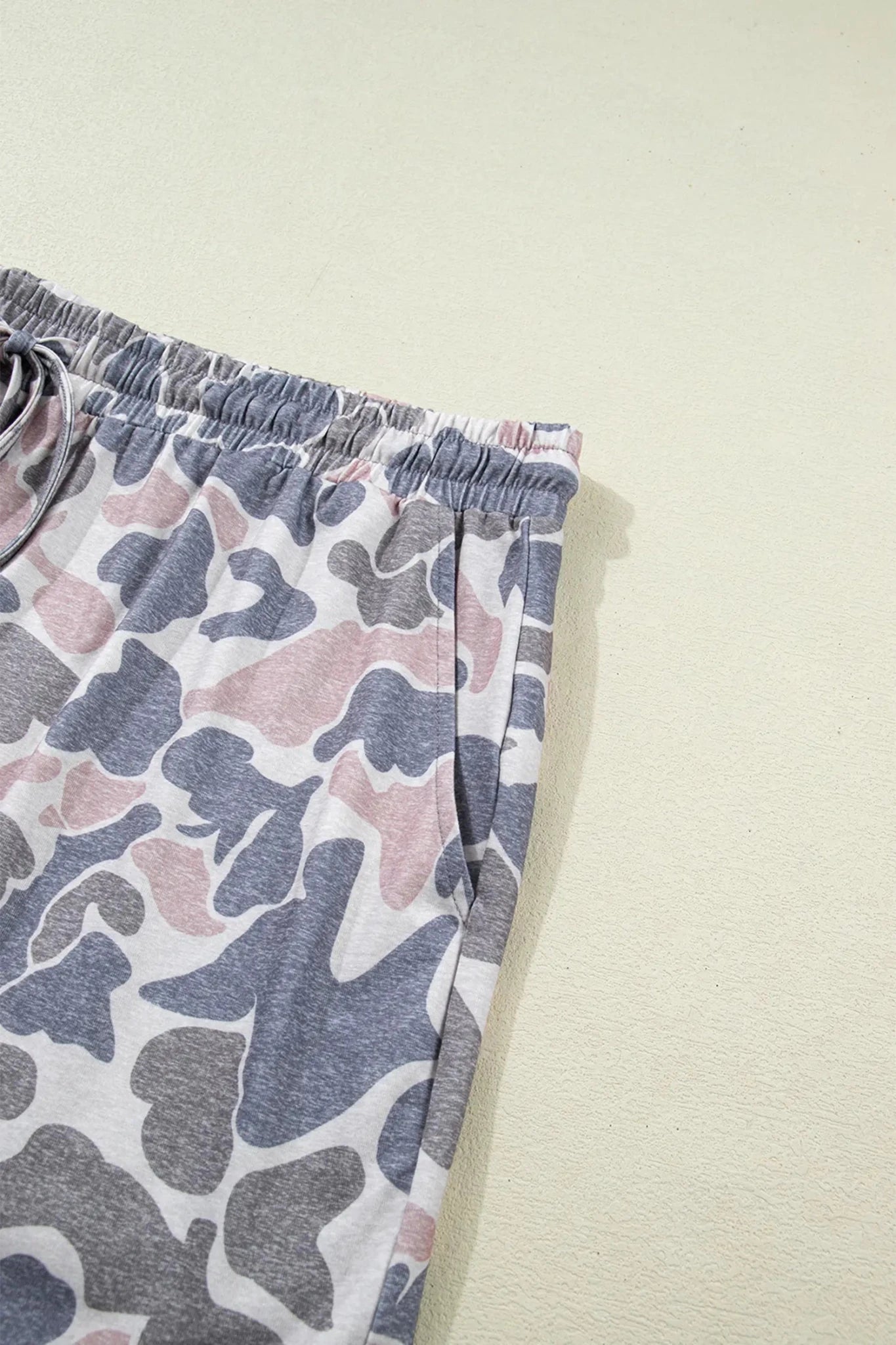 Camouflage-patterned pants on a light beige background