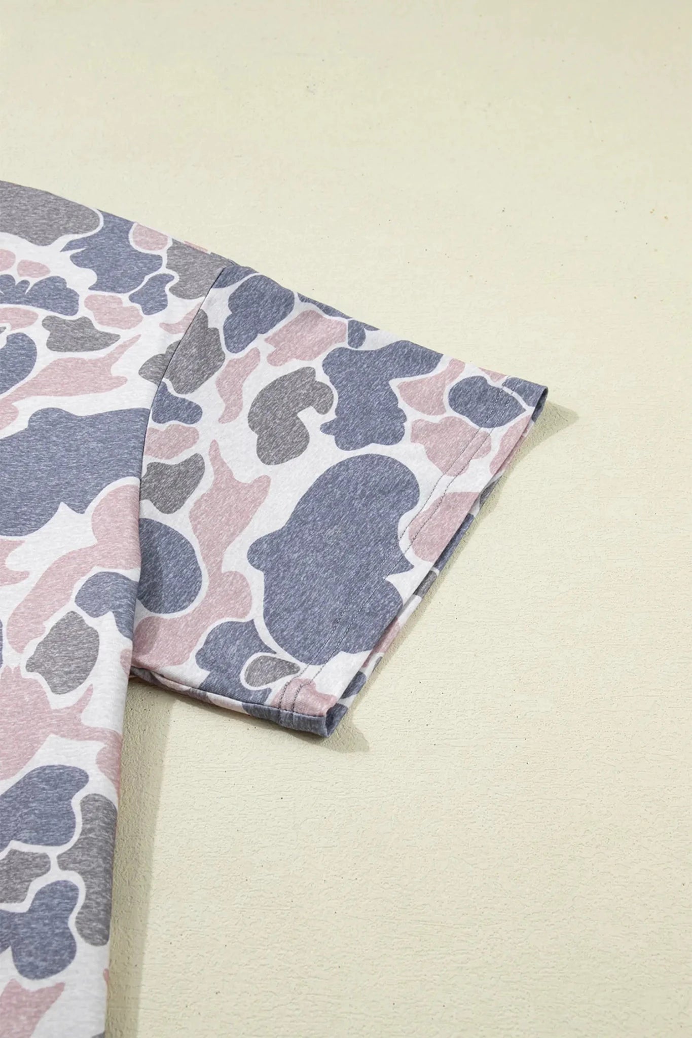 Folded fabric with a camouflage pattern on a light beige background