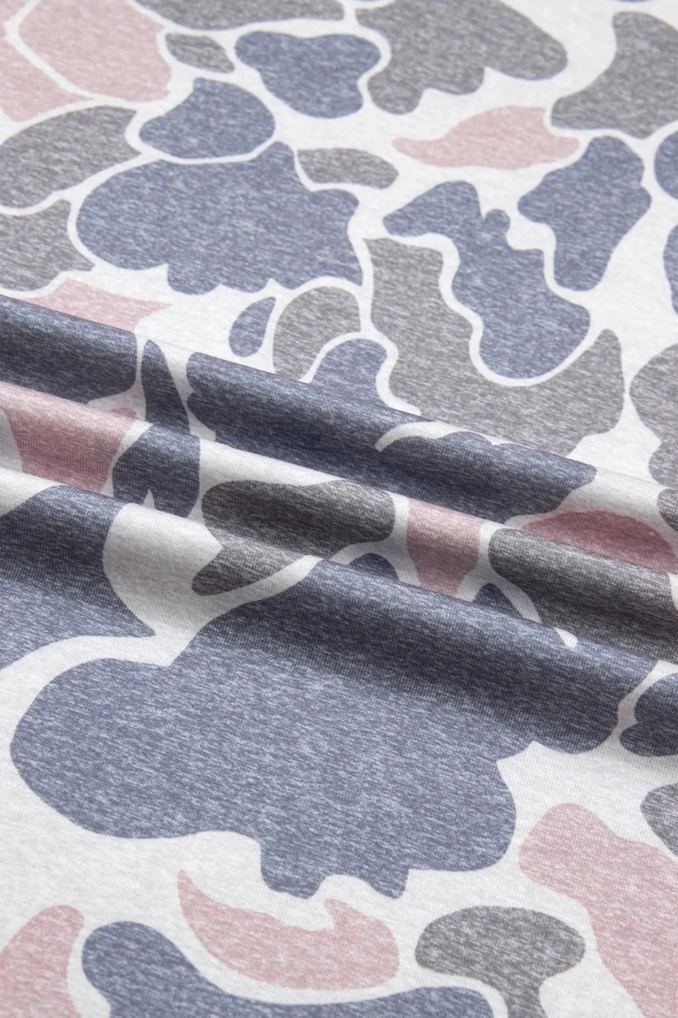 Close-up of fabric with abstract pattern in blue, gray, and pink.