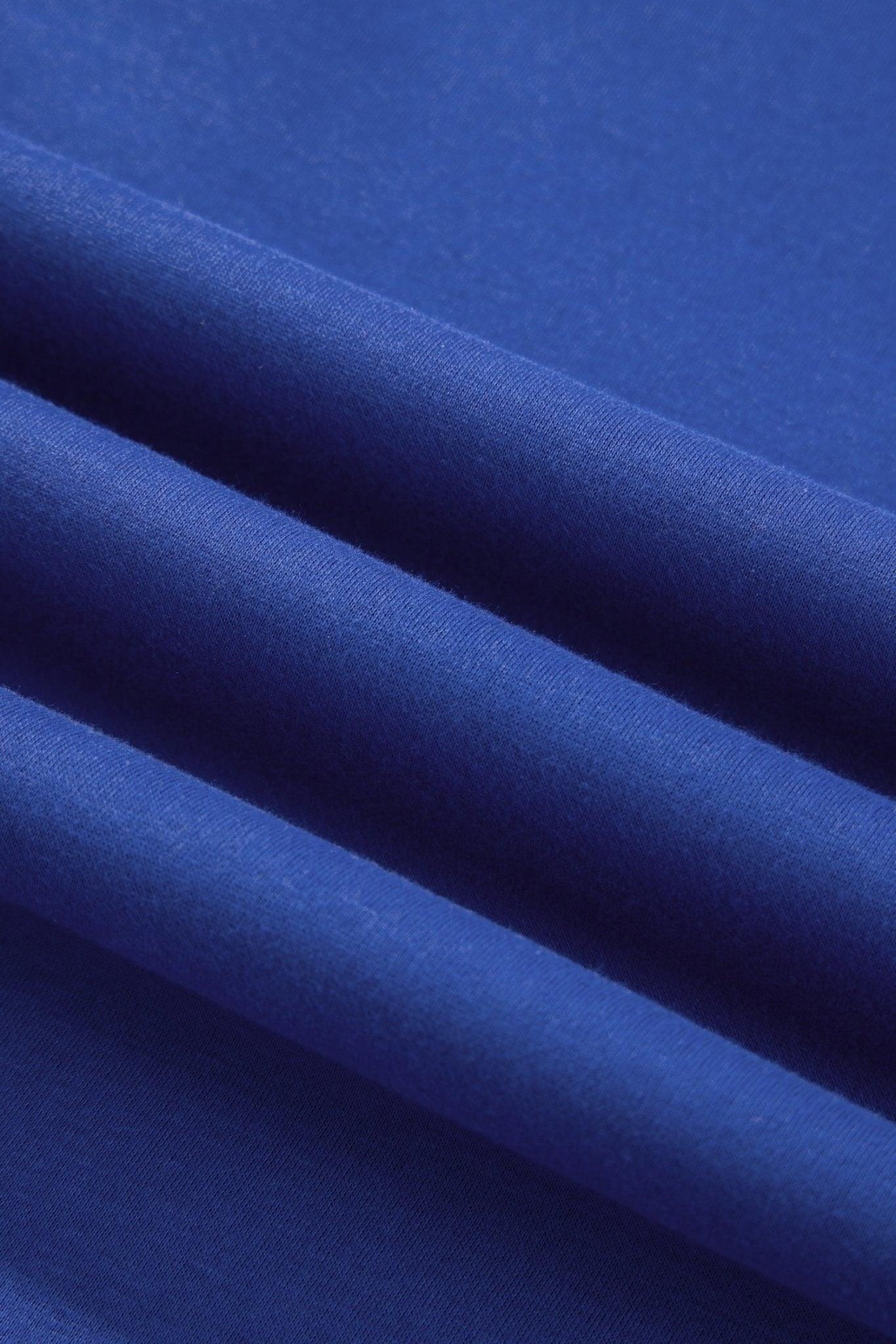 A close-up of folded royal blue fabric showing its smooth texture and drape.