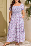 Woman wearing a floral dress standing outdoors against a beige wall.