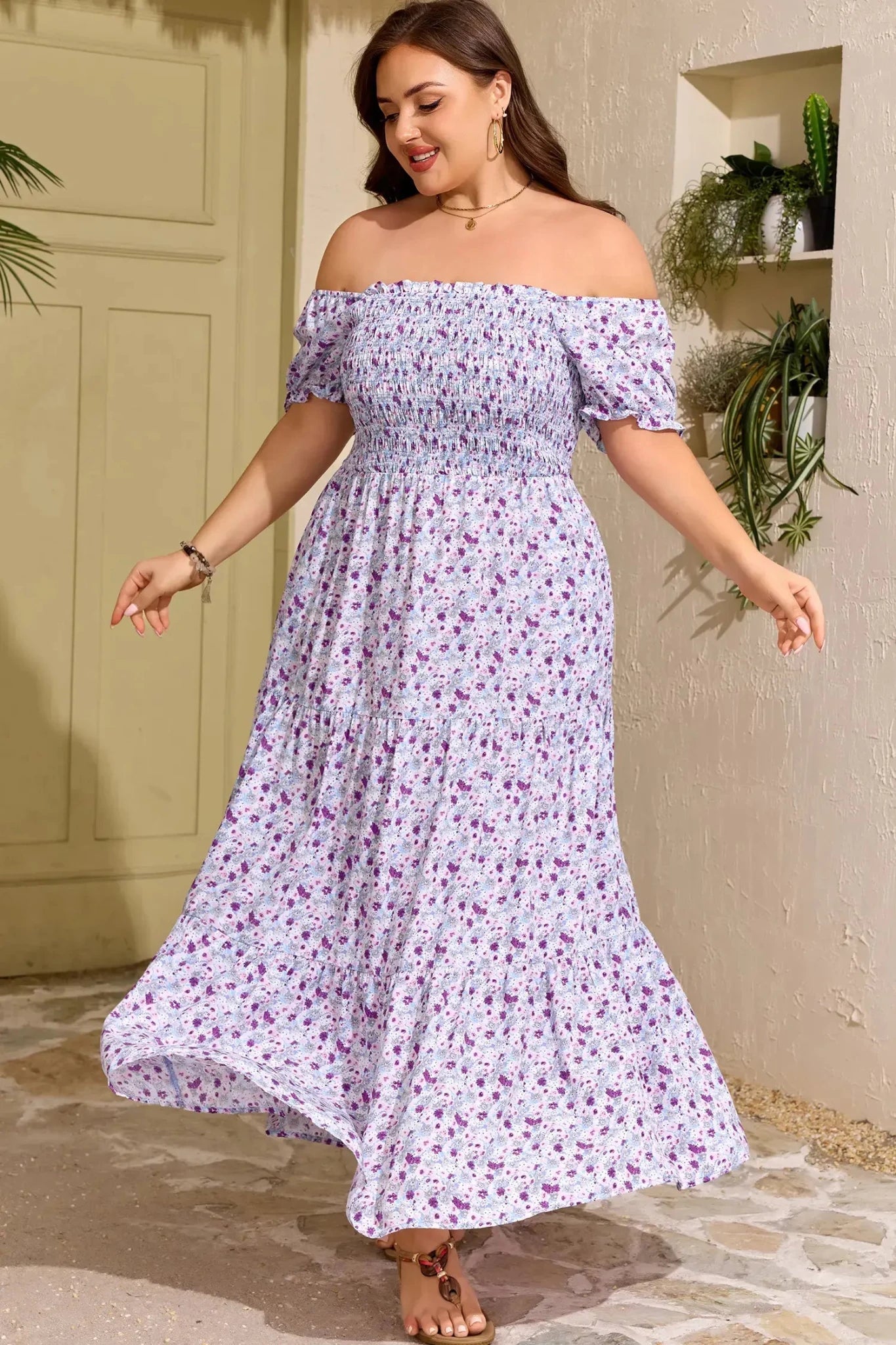 Woman wearing a floral off-shoulder dress standing outdoors.