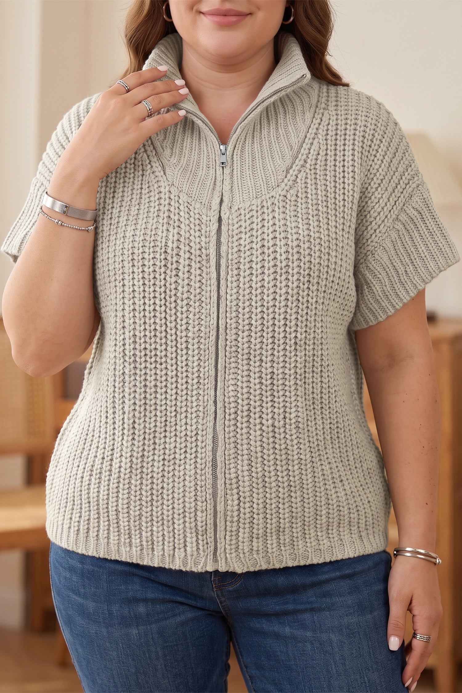 Plus size light gray chunky ribbed knit zip up short sleeve sweater with collar and blue jeans