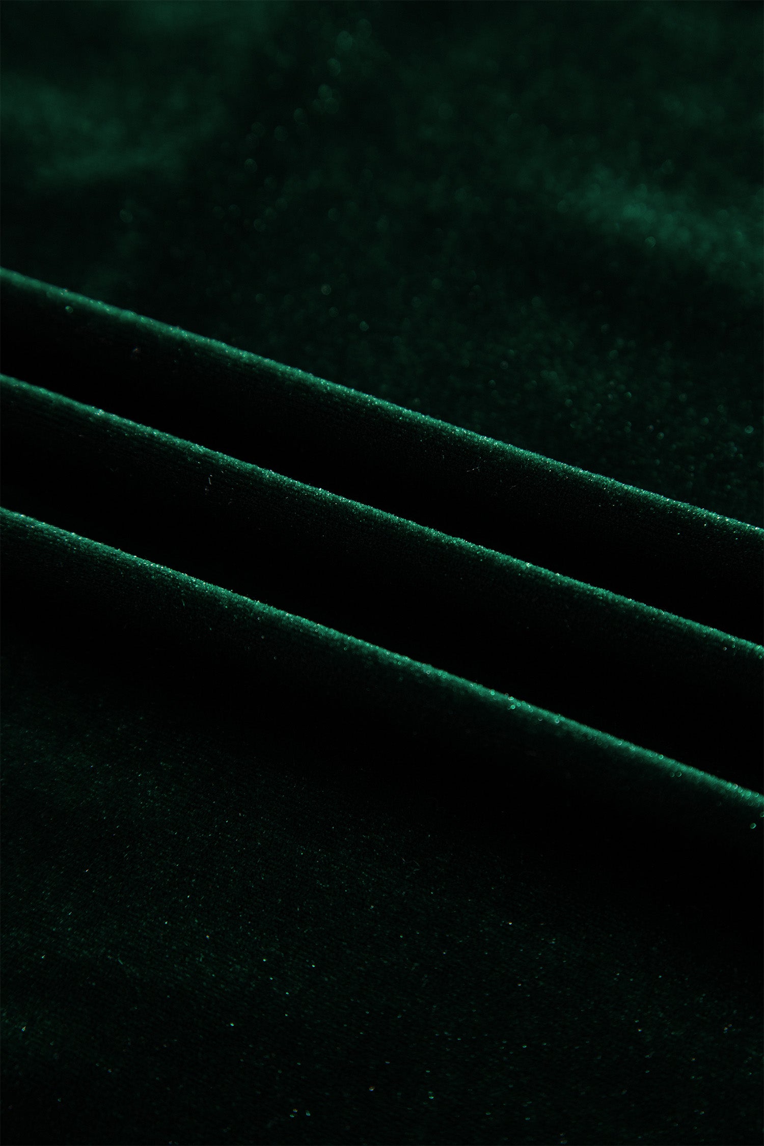 Close-up of soft blackish green velvet fabric with subtle sheen