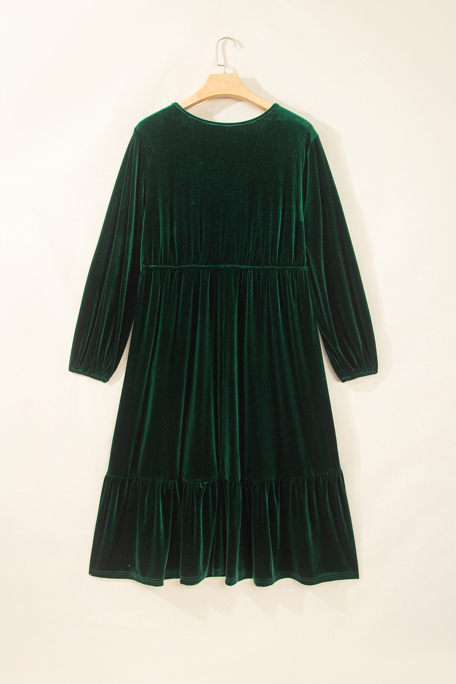 Green velvet long sleeve tiered maxi dress on a hanger, back view
