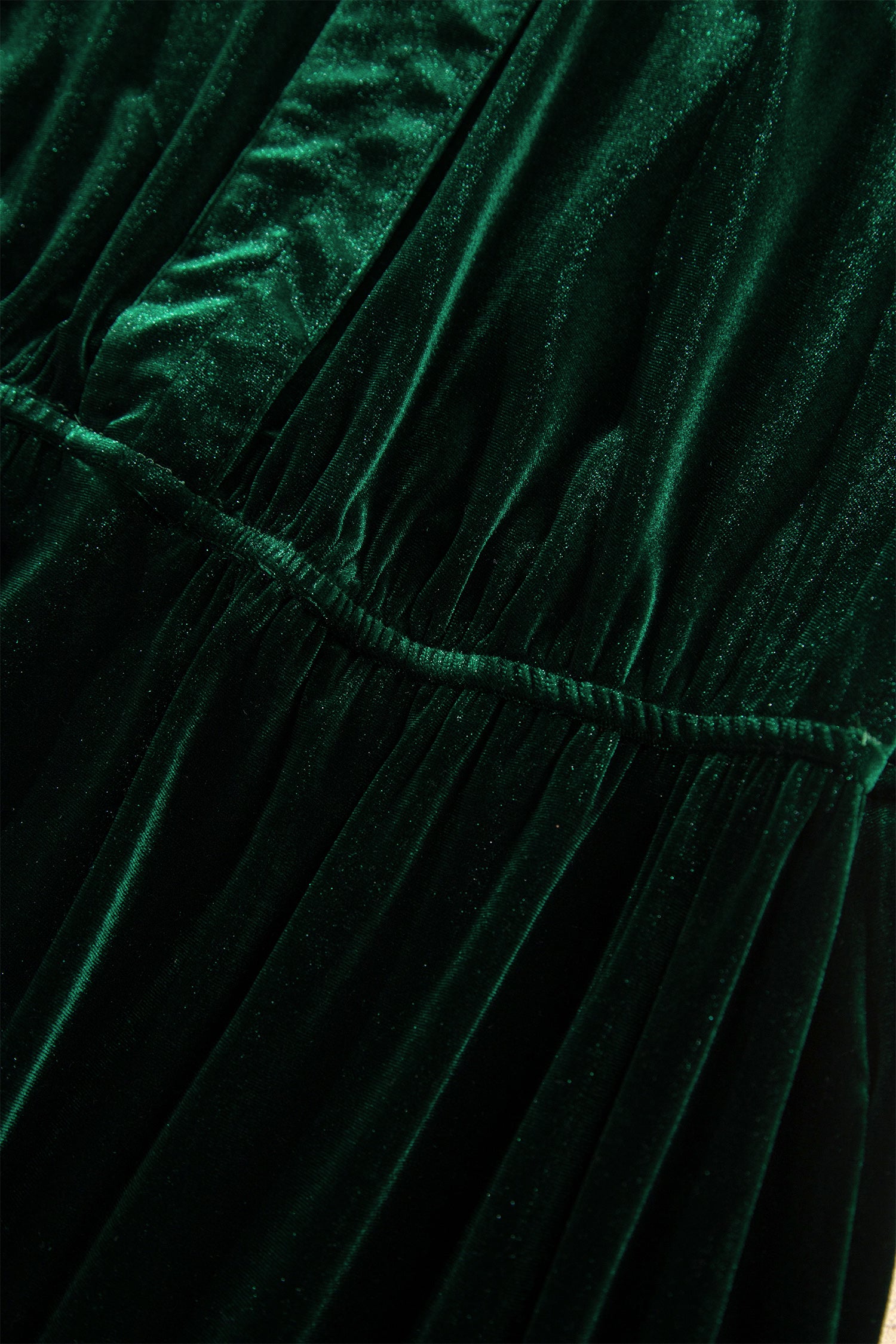 Close-up of gathered elastic empire waist on green velvet maxi dress