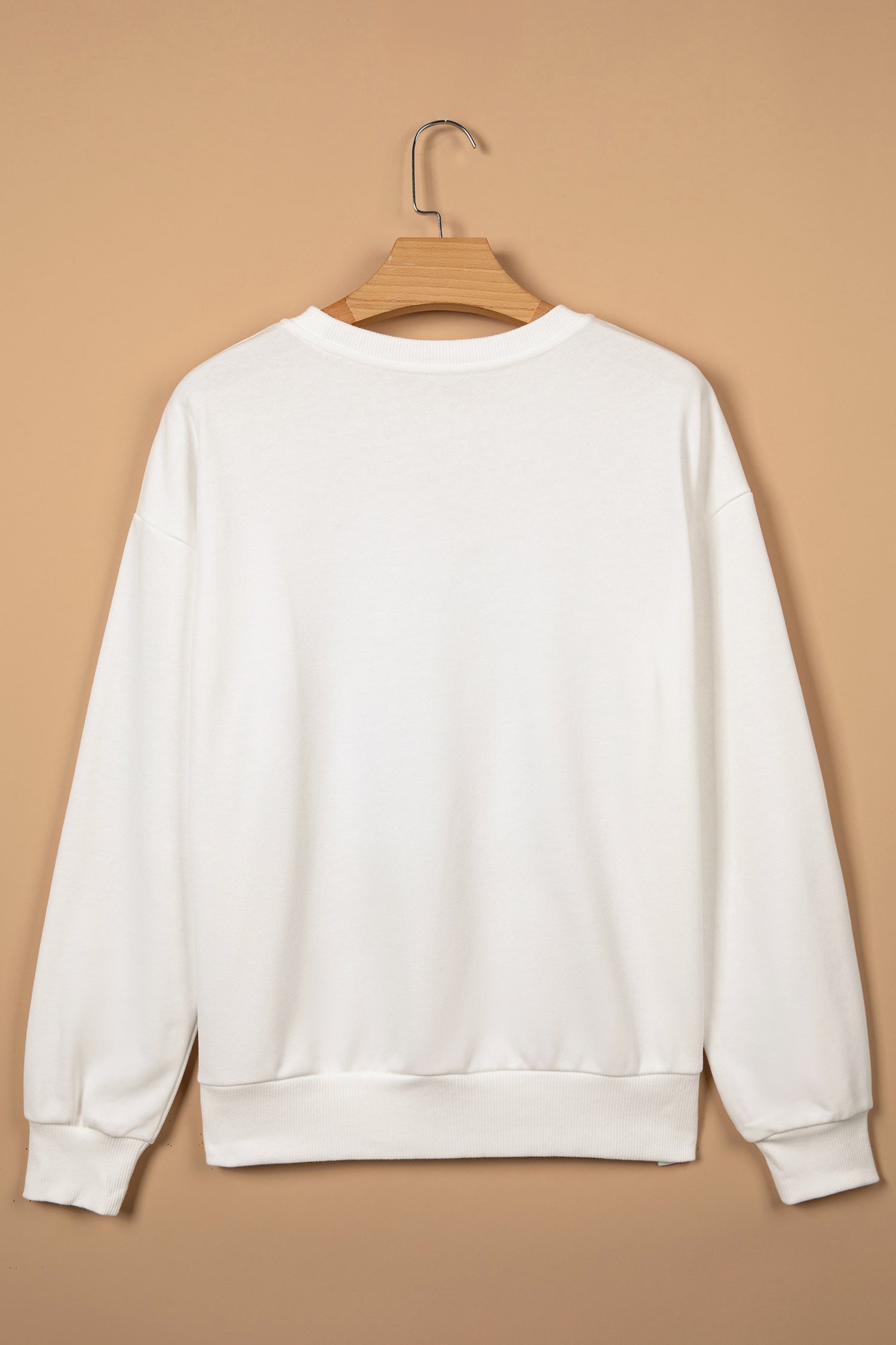 Back view of white crew neck Christmas sweatshirt with ribbed cuffs on a hanger